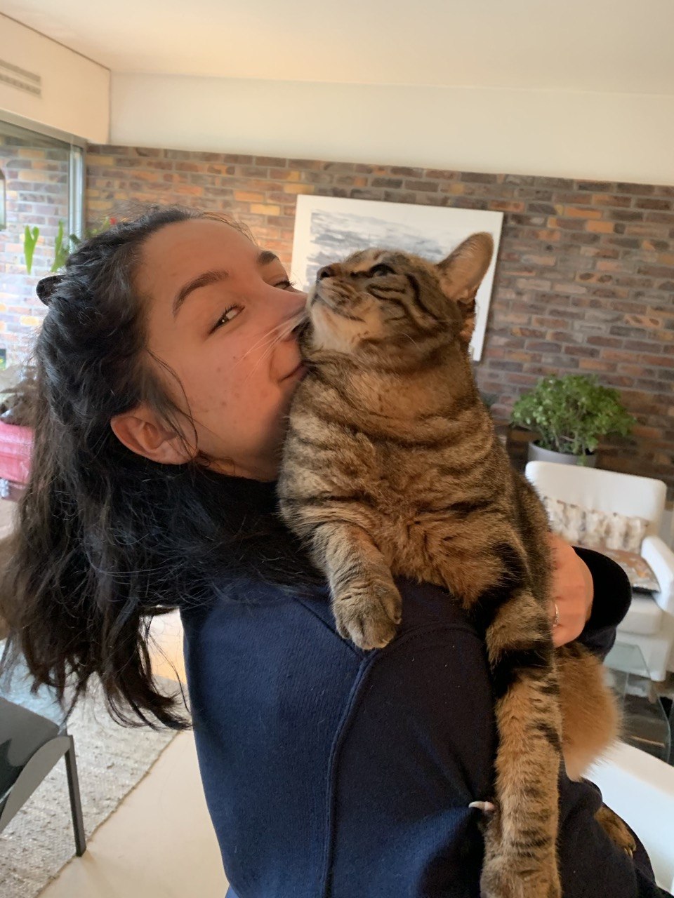 Marion Rahaingomanana avec un chat tigré dans les bras